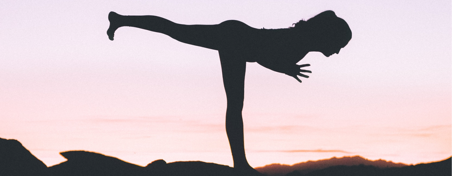 Une femme fais du yoga au crépuscule